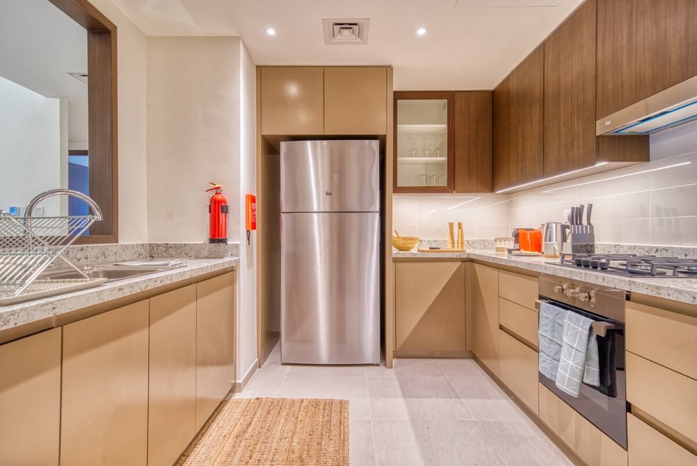 Kitchen with wooden cabinets, fridge and granite countertop