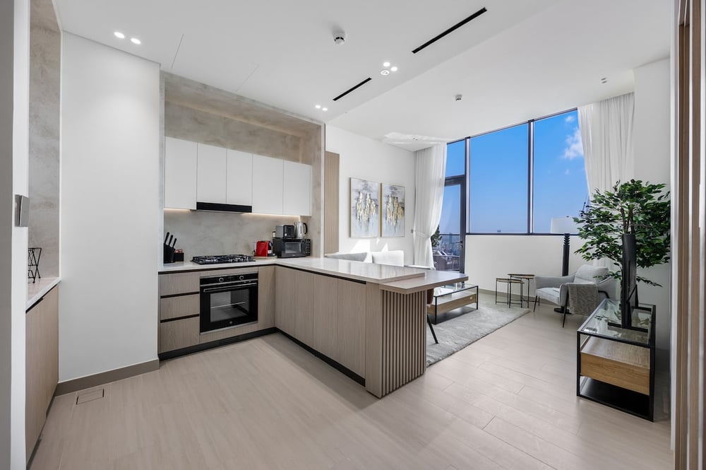 Kitchen with island, oven and open view to living area