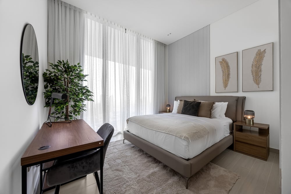 Bedroom with double bed, desk and large curtained window