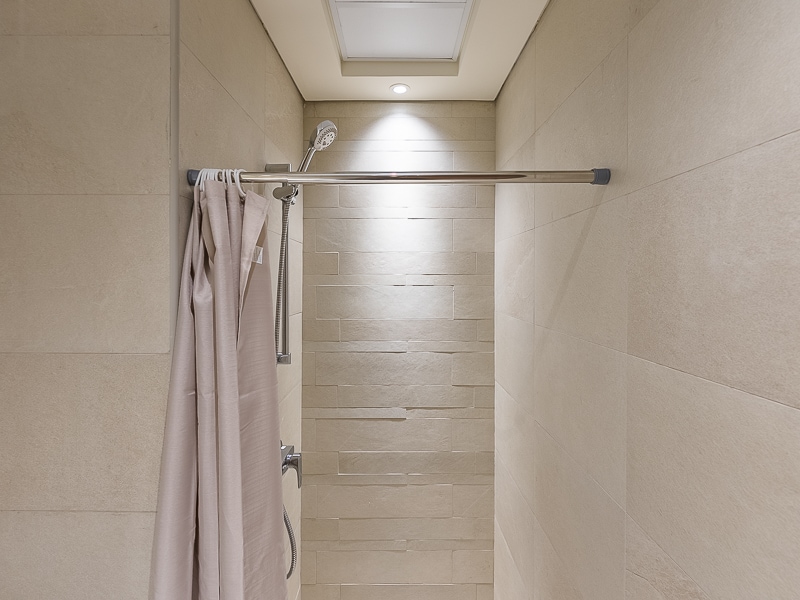 Shower with curtain and overhead light