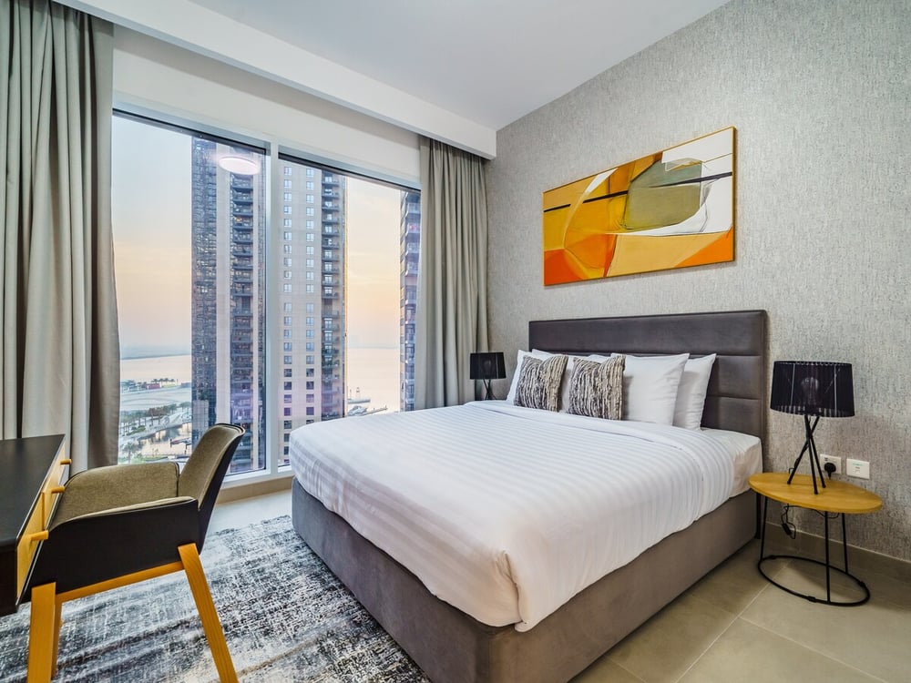 Bedroom with king bed and city view at sunset