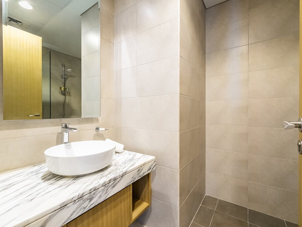 Bathroom with vessel sink on marble countertop and mirror