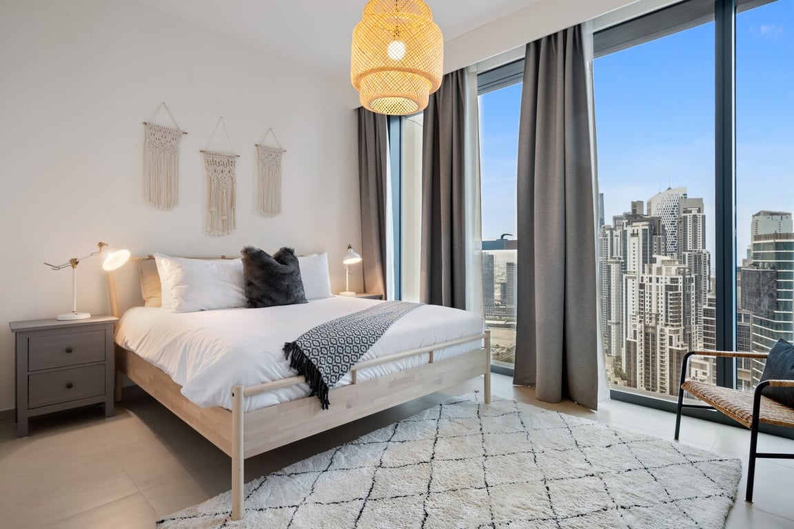 Bedroom with king bed, macrame wall decor and city view