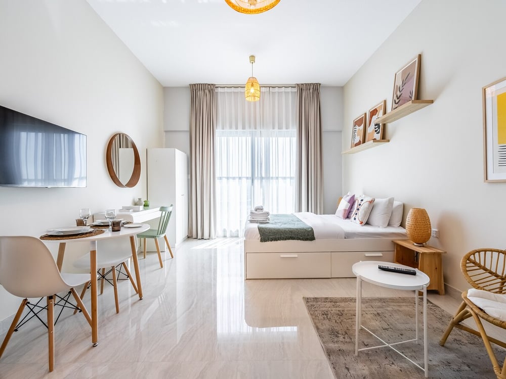 Studio living area with sofa dining table and TV