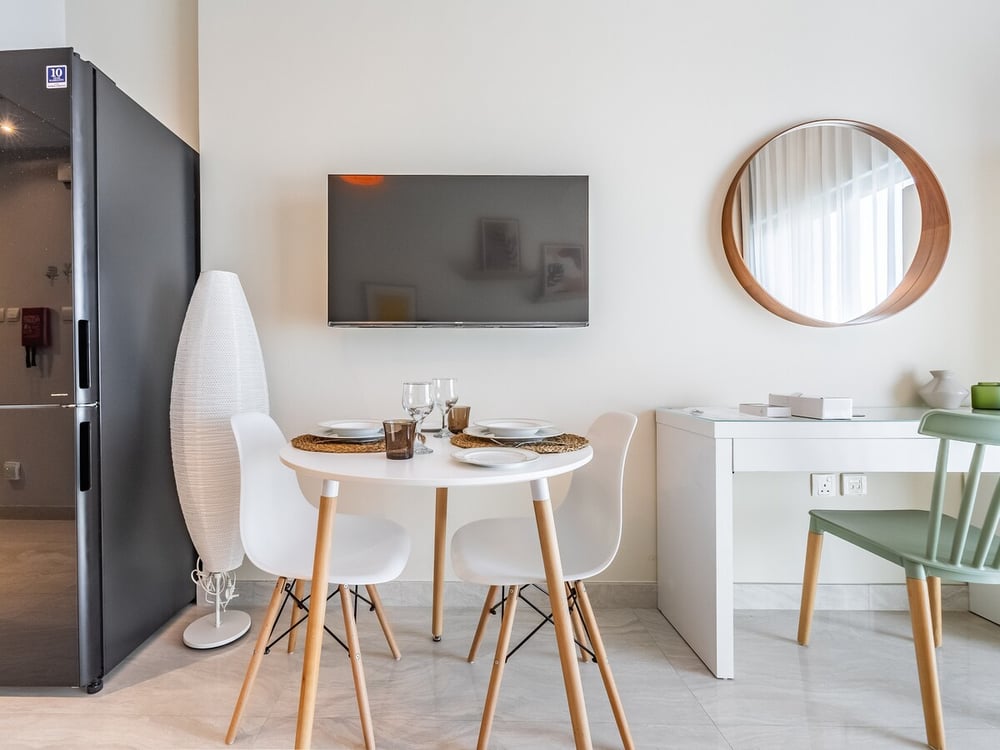Studio dining area with round table TV and mirror