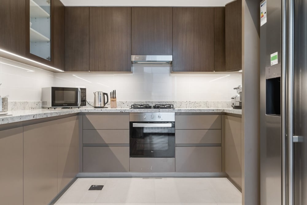 Modern kitchen with dark cabinetry, oven and fridge
