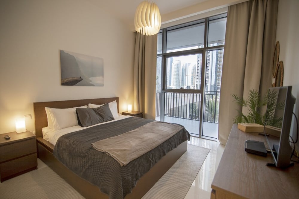 Bedroom with double bed, nightstands, TV and balcony view