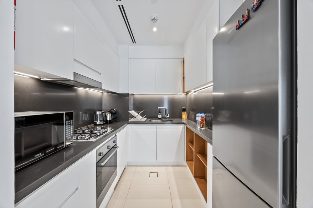 Modern white kitchen with fridge and dark countertops