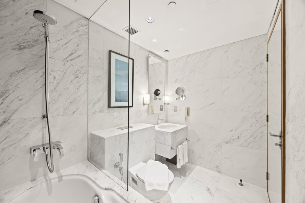 Marble bathroom with bathtub and glass shower enclosure