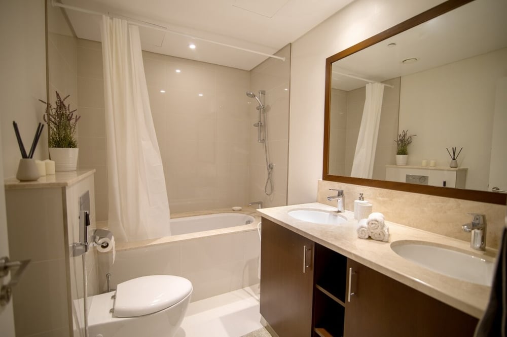 Bathroom with bathtub, shower, toilet, vanity and large mirror