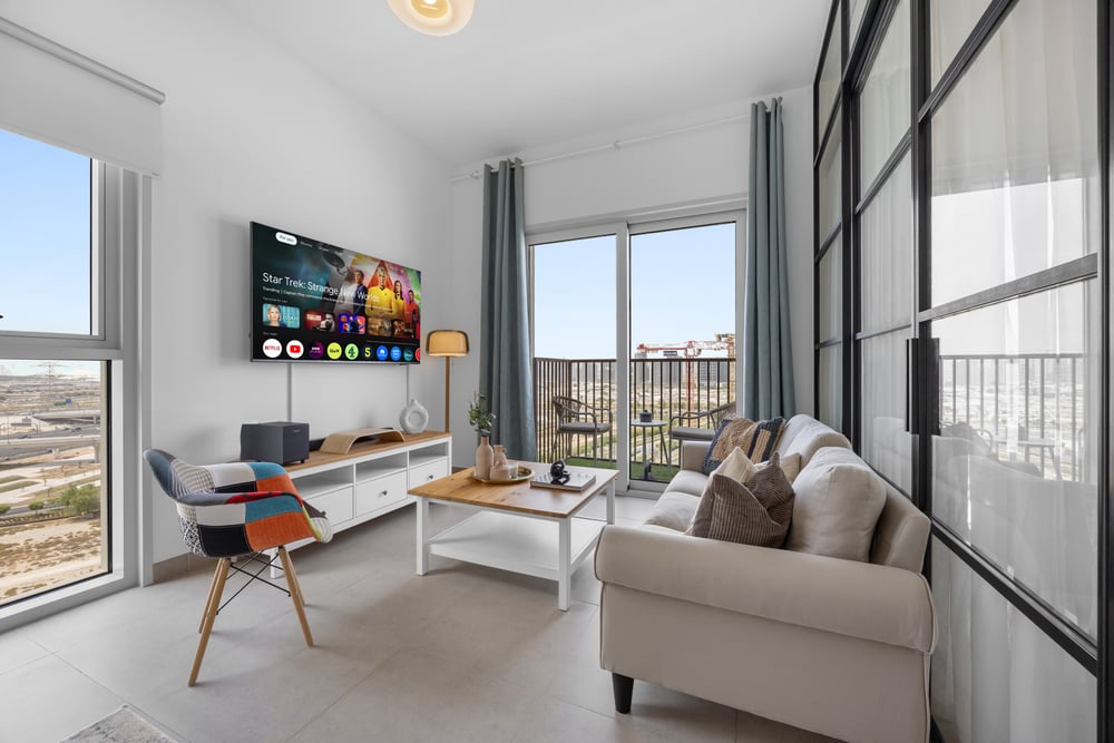 Bright living area with large TV, sofa, and panoramic windows