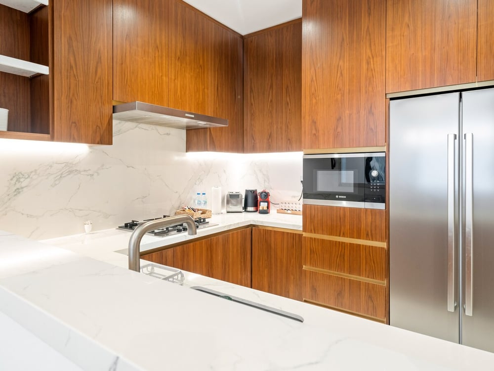 Kitchen with fridge, hob and wooden cabinetry