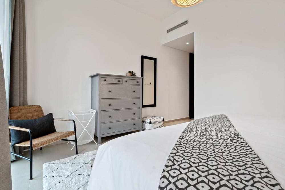 Bedroom with dresser, mirror and lounge chair
