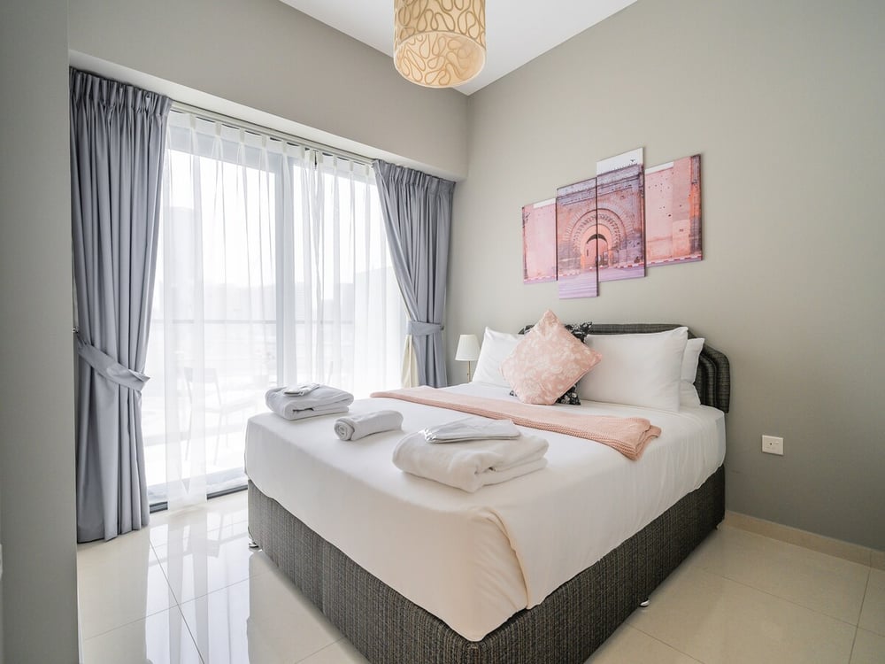 Bedroom with double bed white linen and large window