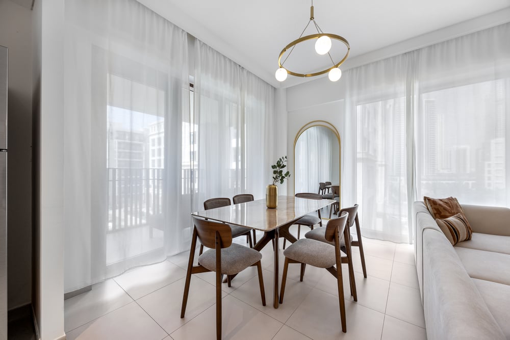 Dining area with arched mirror and bright windows
