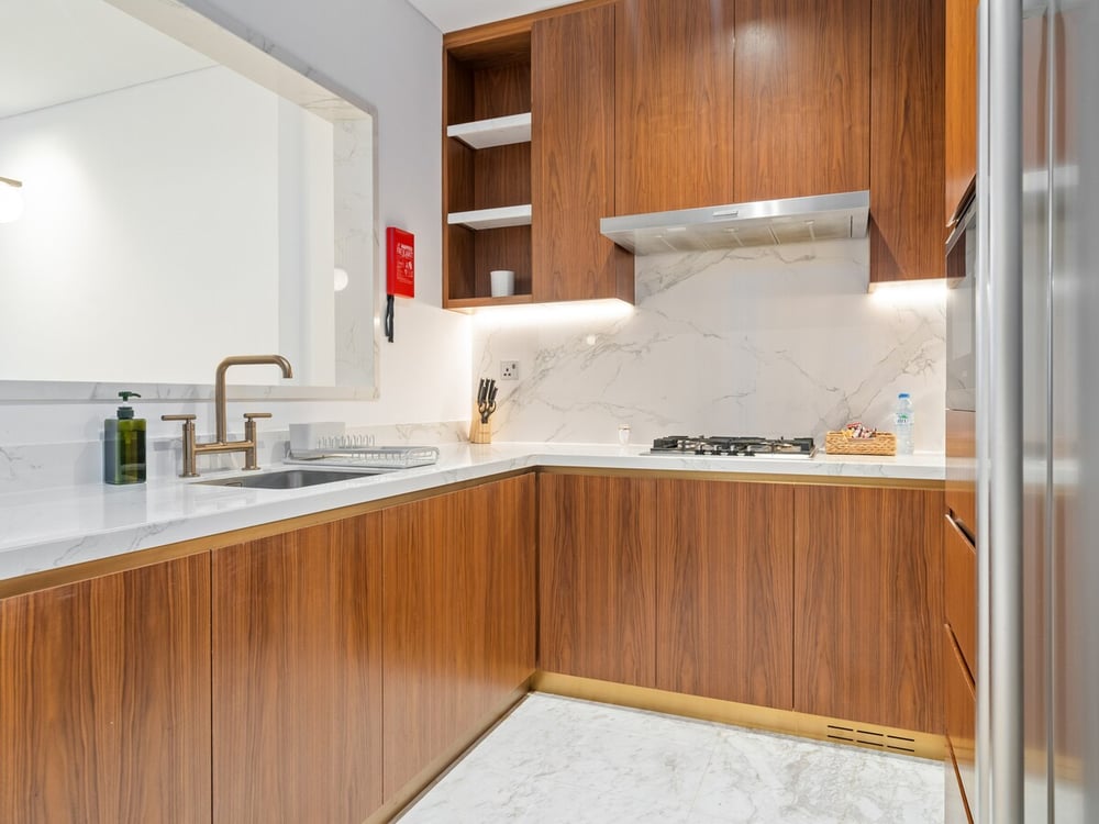 Kitchen with wooden cabinetry and marble backsplash