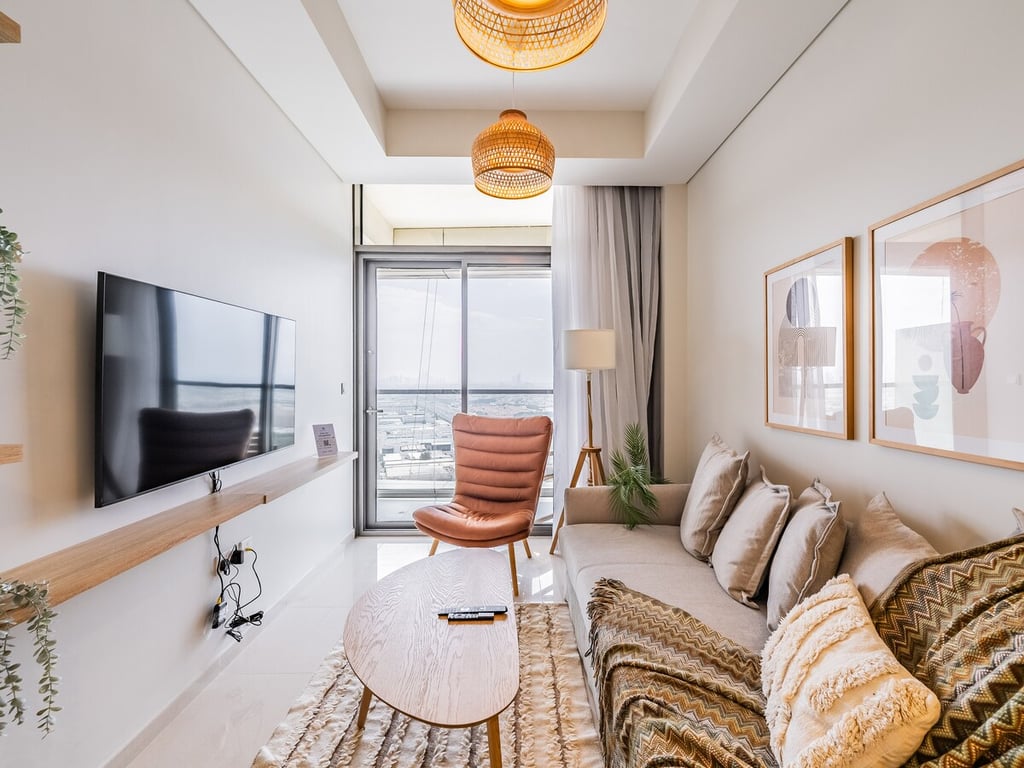 Living room with sofa, TV, balcony view and city panorama
