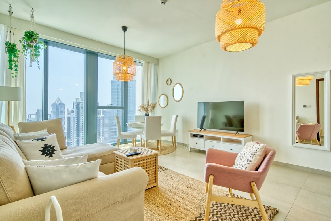 Open-plan living room with sofa, TV and city view window