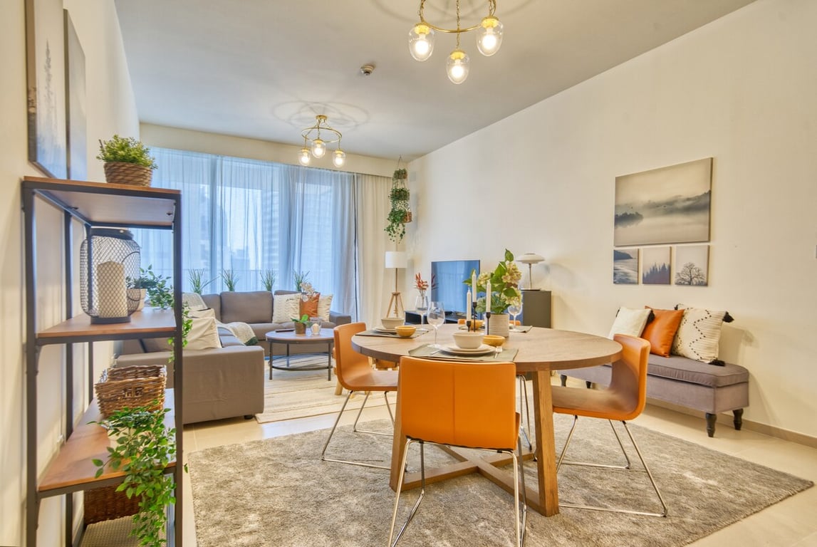 Living and dining area with chandelier and orange chairs