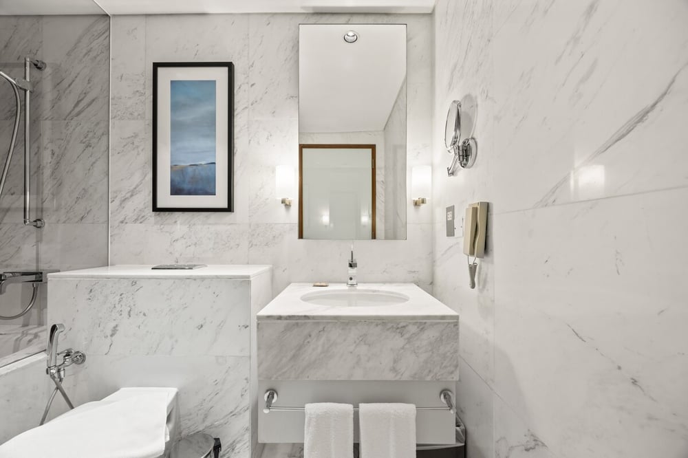 Marble bathroom with bathtub, sink and toilet