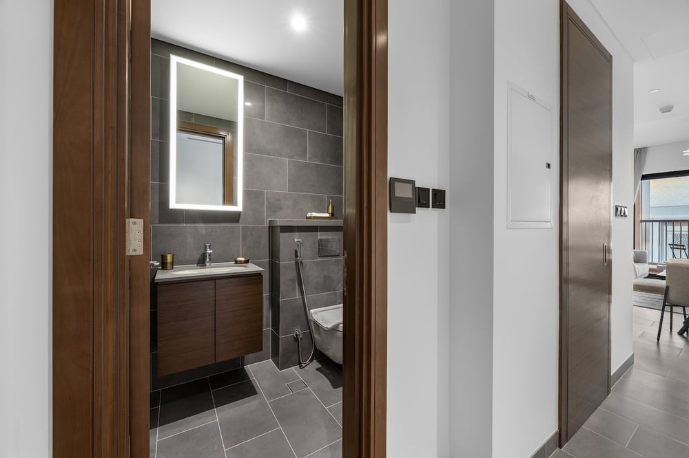 Hallway view into bathroom with vanity and toilet