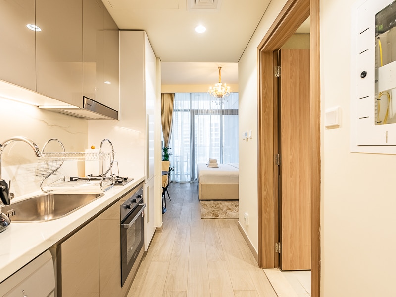 Studio kitchen corridor with sleeping area visible beyond