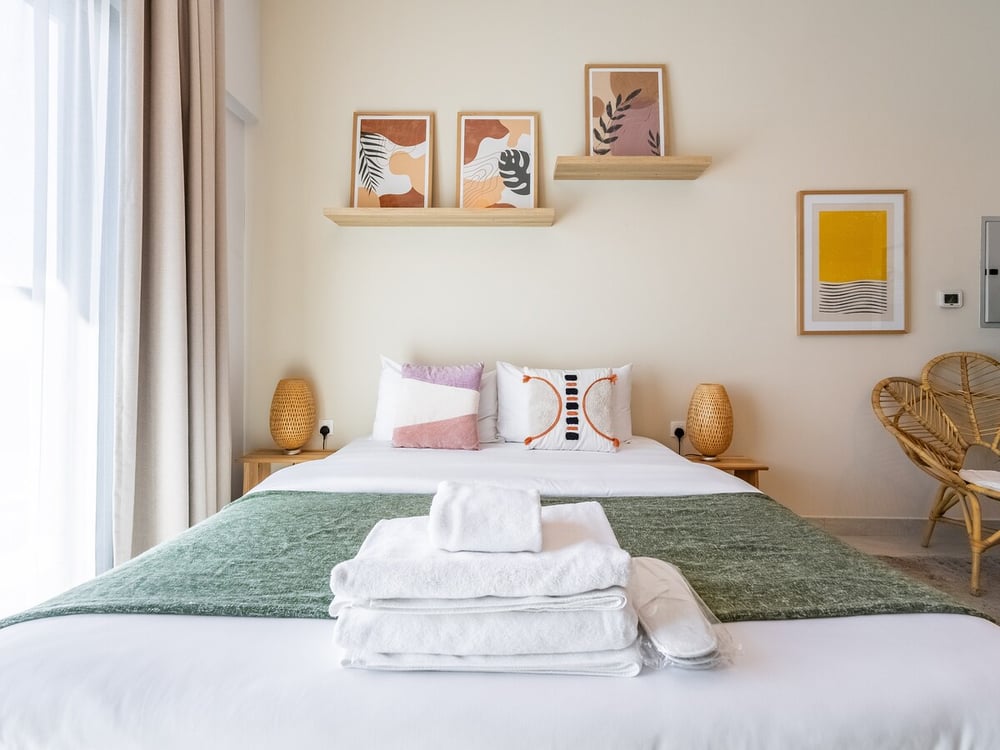 Double bed with green throw and decorative pillows