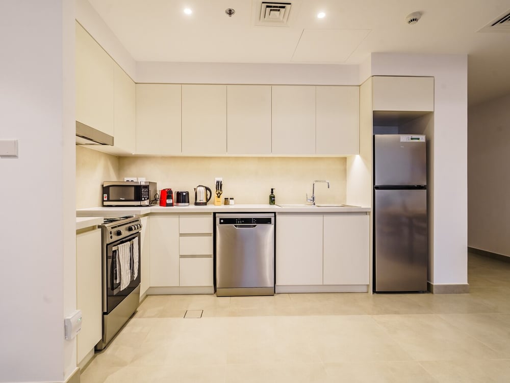 Modern white kitchen with fridge, oven and dishwasher