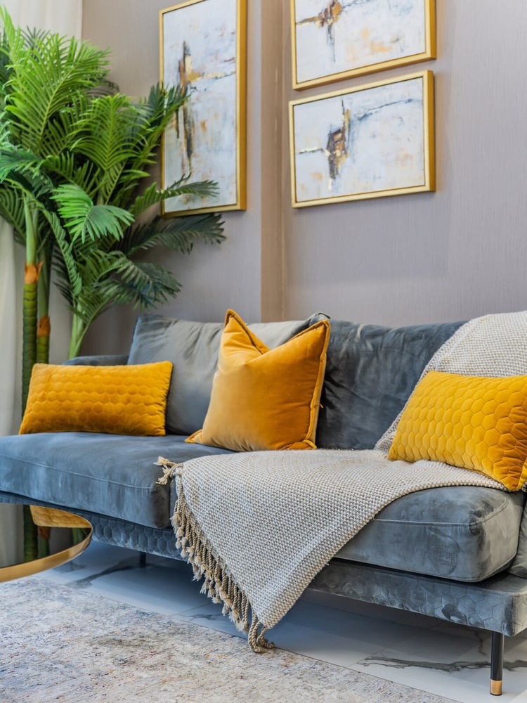 Close-up of grey sofa with yellow and white cushions