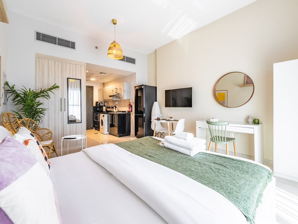 Studio with double bed sofa dining table and TV