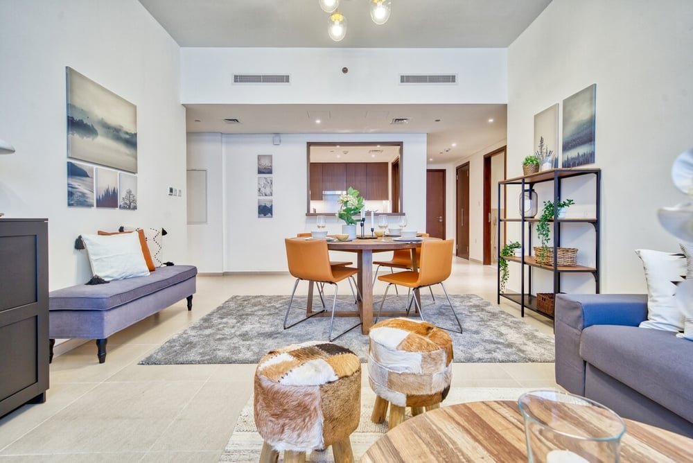 Open-plan living and dining with blue sofa and accent tables