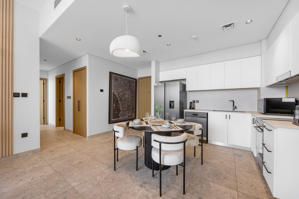 Dining table with chairs and kitchen in background