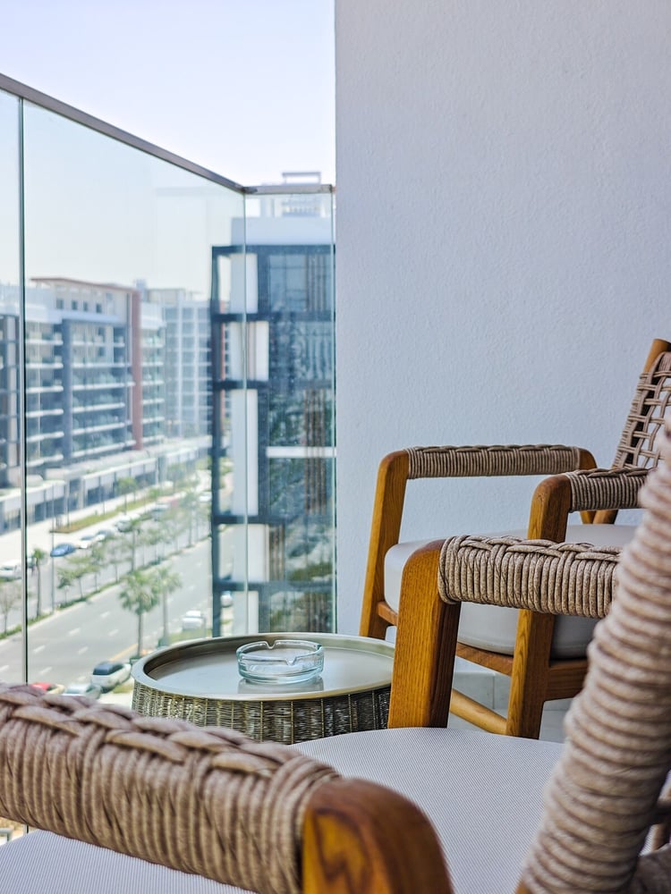 Balcony with rattan chairs and glass railing