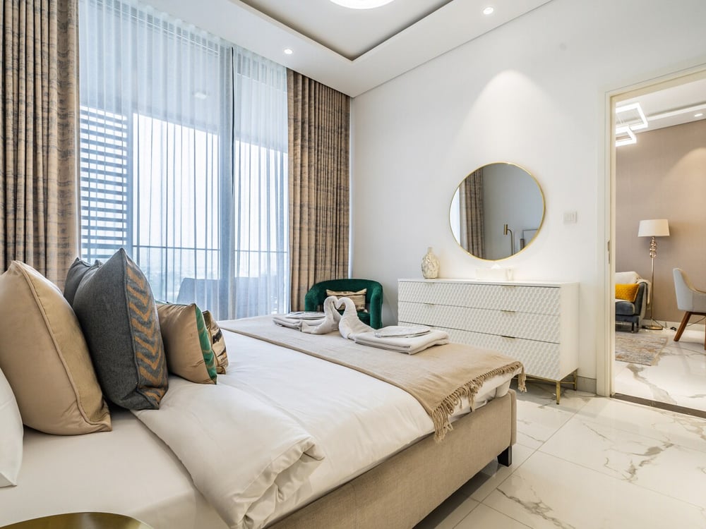 Bedroom with double bed dresser and round mirror