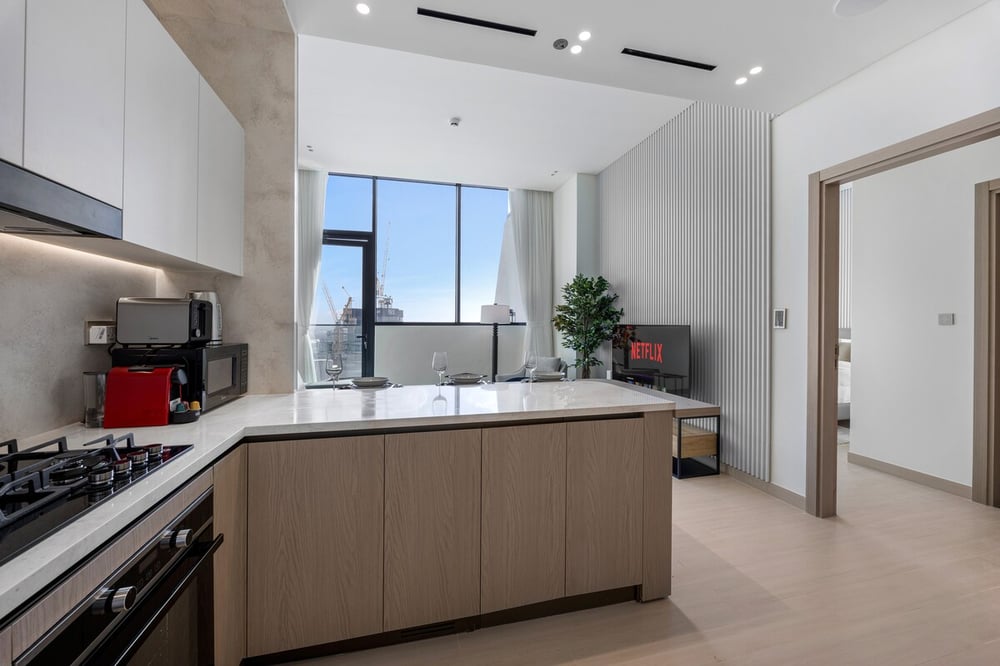 Modern kitchen with gas hob, oven and island overlooking living area