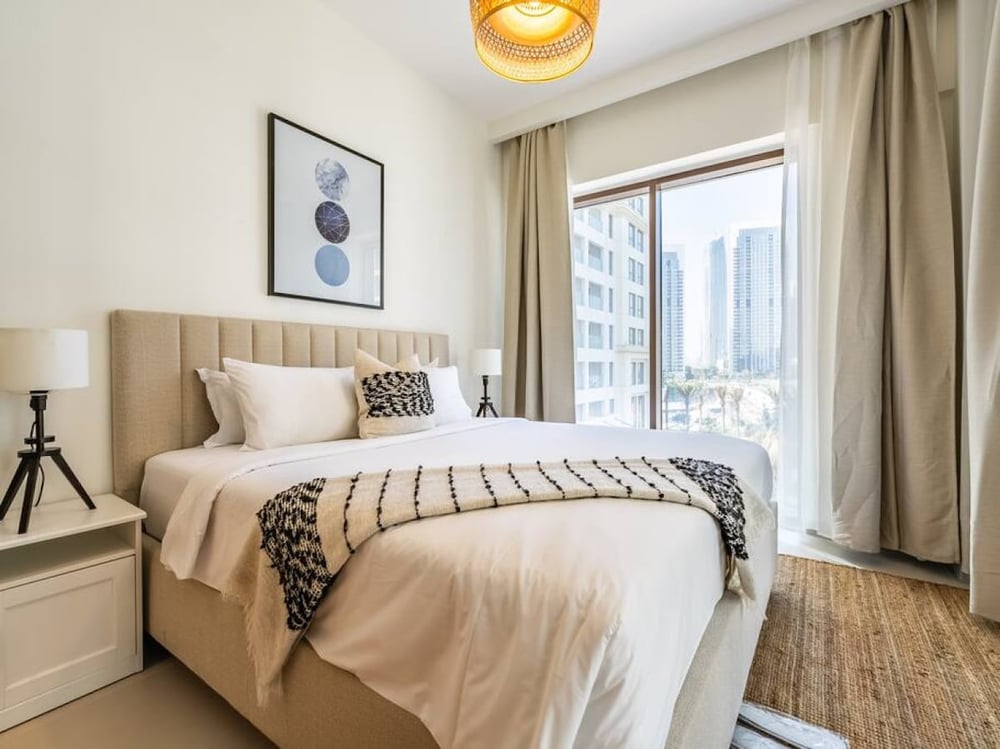 Bedroom with queen bed beige headboard and balcony view