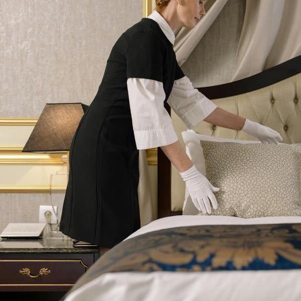 Service conciergerie luxe MONA Paris - Personnel en uniforme préparant une suite 5 étoiles - Service hôtelier premium 24/7