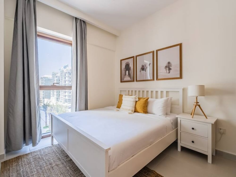 Bedroom with double bed yellow cushions and balcony