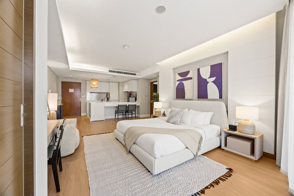 Studio with king bed, artwork and open kitchen behind