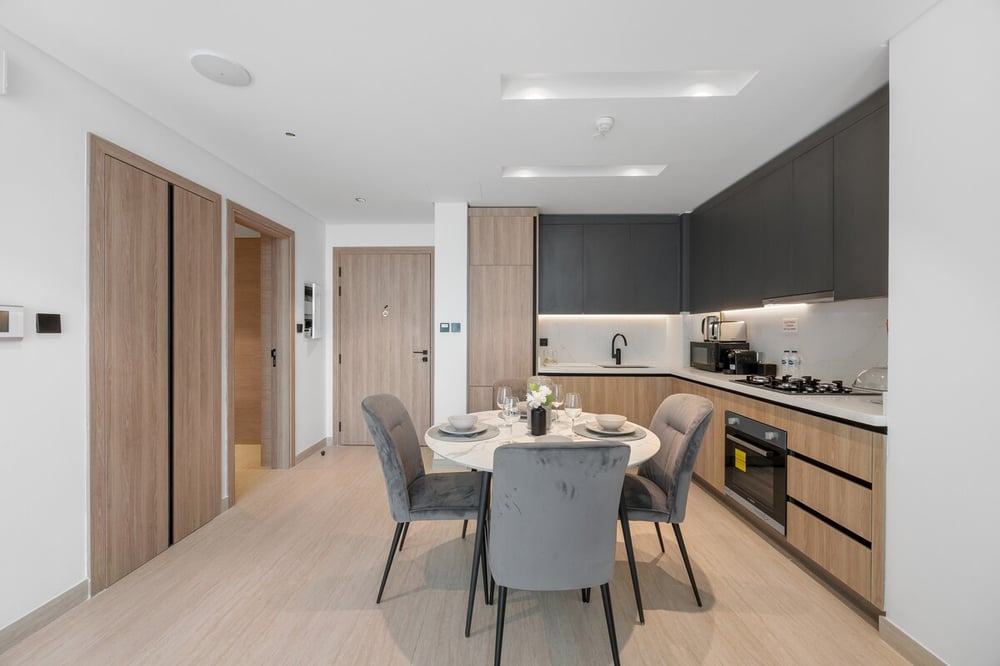 Kitchen and dining area with oven visible and dark upper cabinets