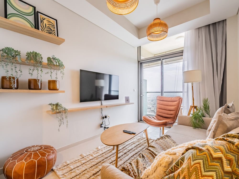 Living room with sofa, TV unit, plants and balcony access