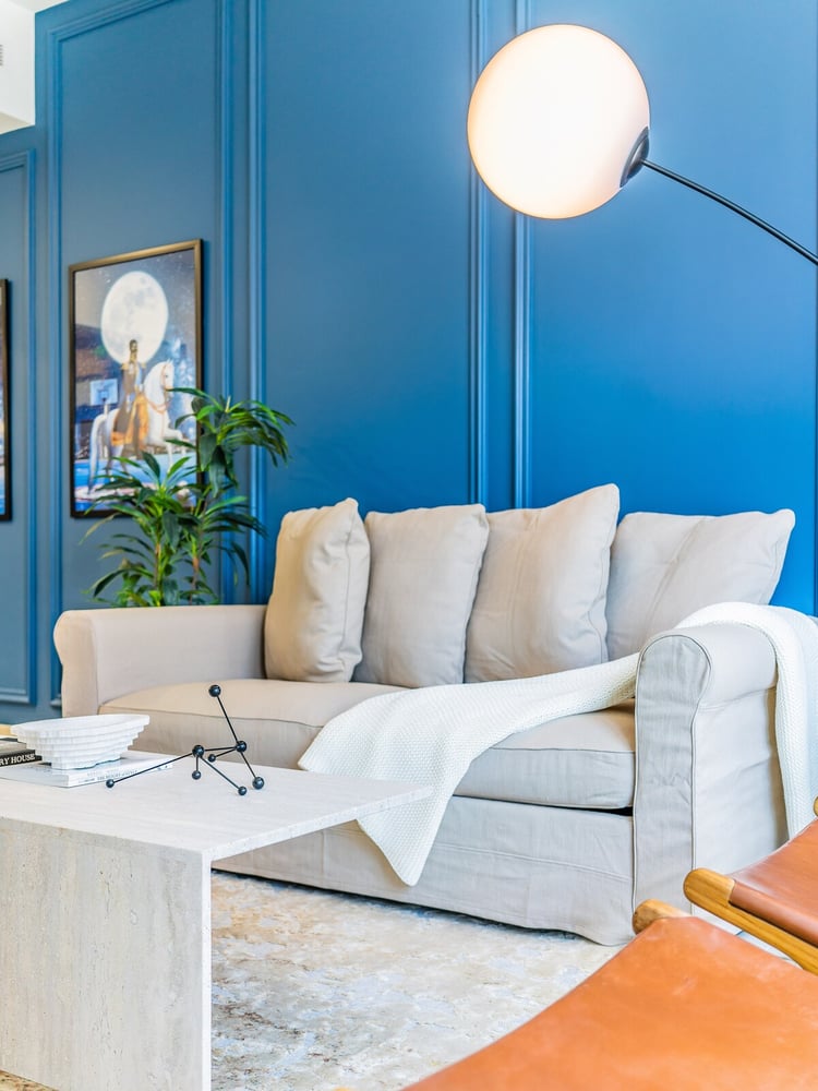 Living room blue wall sofa and floor lamp