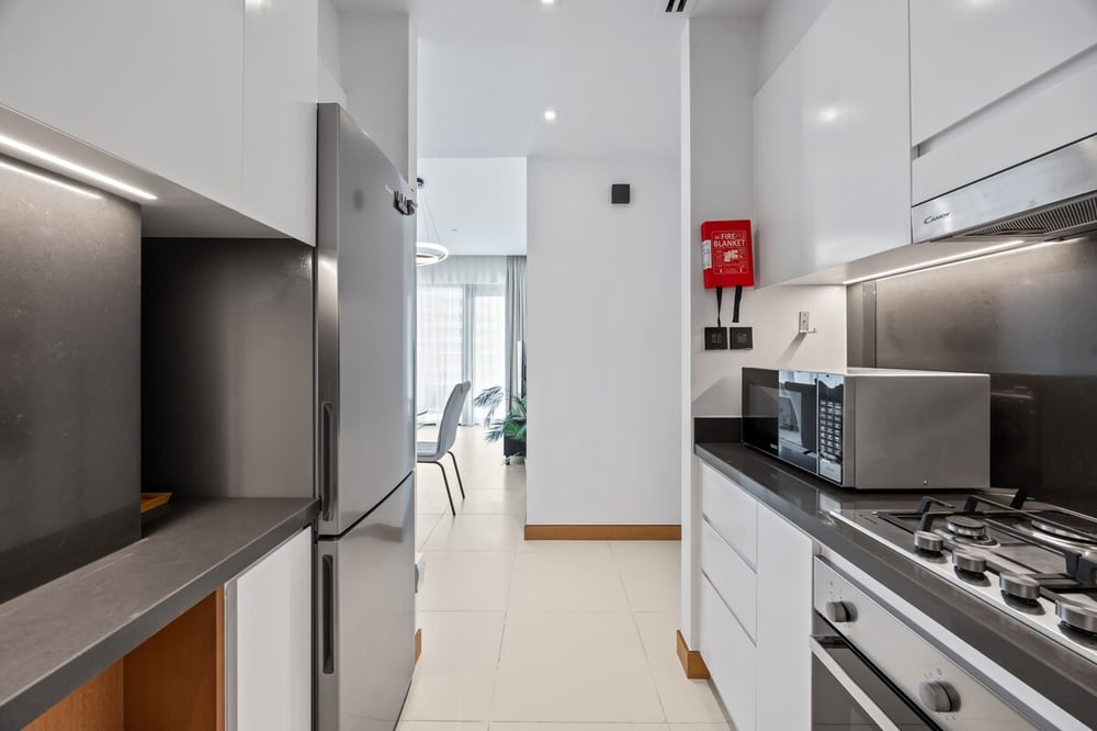 Narrow kitchen with fridge, microwave and fire extinguisher