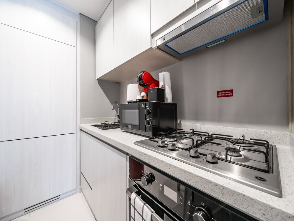Kitchen with gas hob microwave fridge and hood