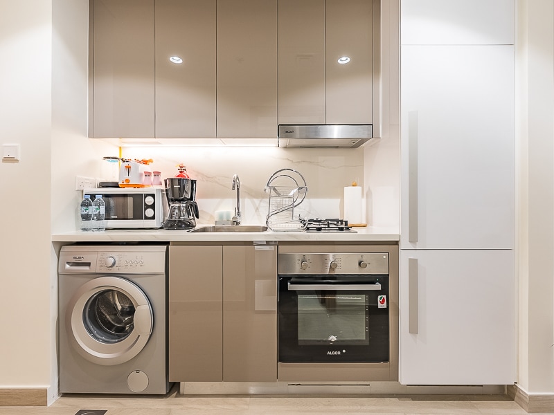 Kitchen with washing machine, oven, fridge and hood