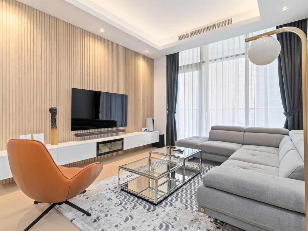 Living room with L-shaped sofa, TV and armchair