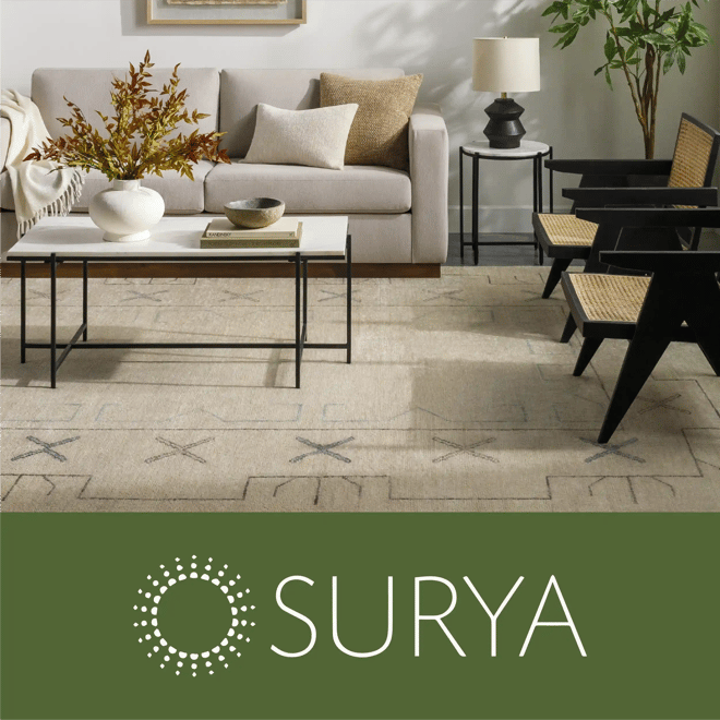 Surya image of a living room featuring a large area rug, beige sofa, and two arm chairs.