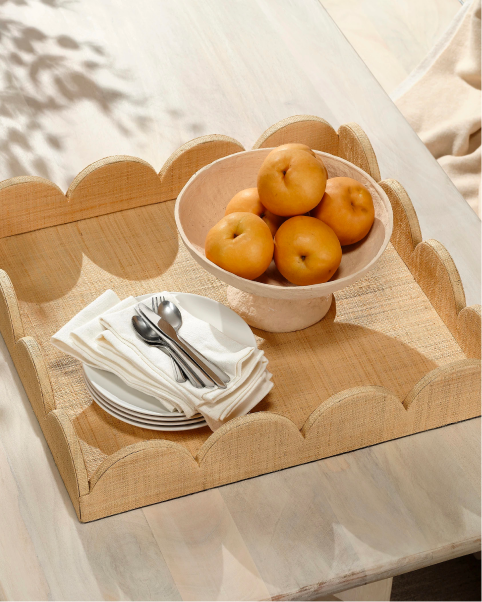 Scalloped neutral serving tray with a bowl of fruit.