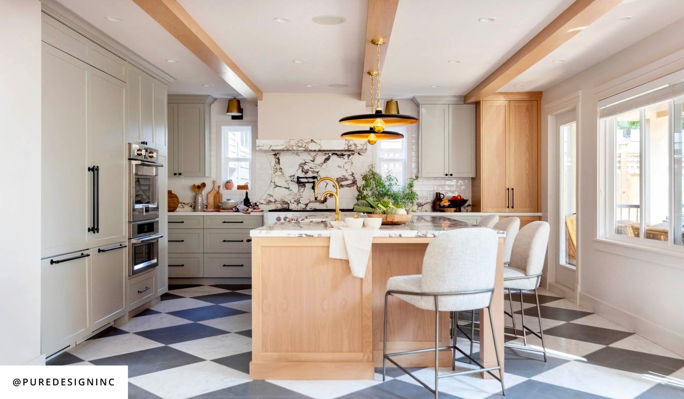 Design by PURE Interior Design, A kitchen with white cabinets and a black and white checkered floor. A classic and stylish design.