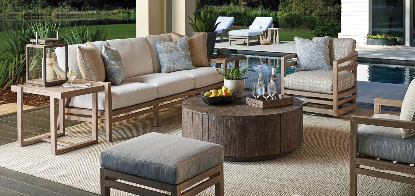 An outdoor living room with furniture and a coffee table.